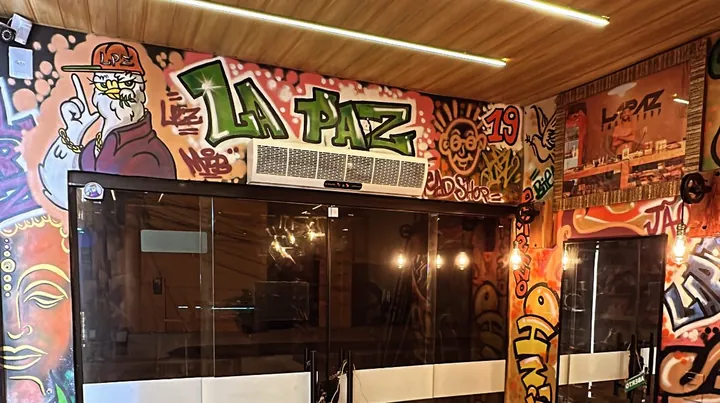 Entrada da loja na Rua da Pituba, toda grafitada com LA PAZ